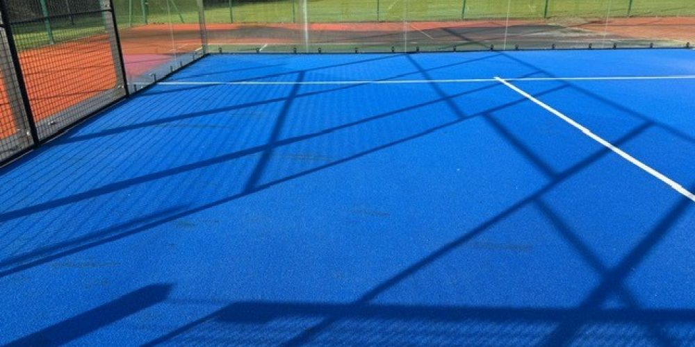 Soft-bristle central brush of a Columbus court sweeper combing synthetic turf fibers to prevent compaction.