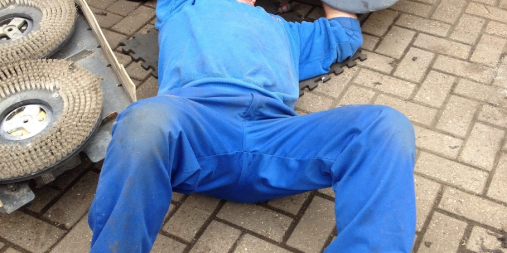 On-site technician performing maintenance on industrial floor cleaning equipment at a Sunderland facility.