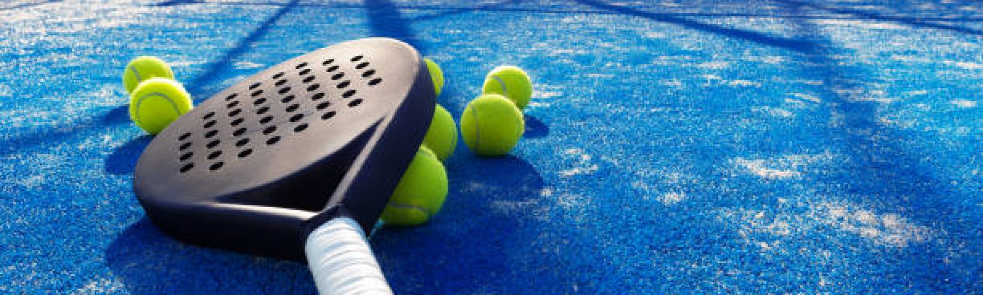 paddle tennis racket and balls on the blue paddle court